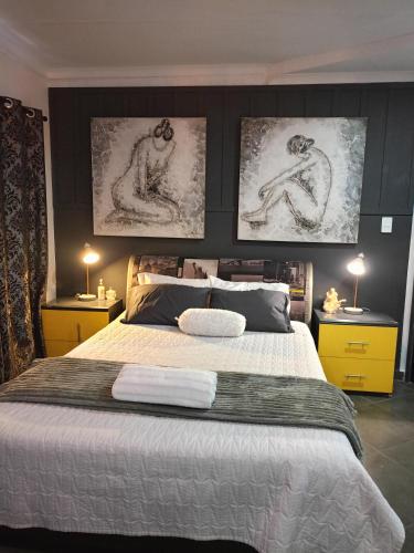 een slaapkamer met een groot bed met twee foto's aan de muur bij Vanilla Lee Corporate Suite in Richards Bay
