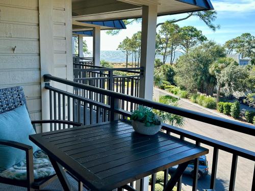 a wooden table on a porch with a view of the ocean at Seaside 382 in Hilton Head Island
