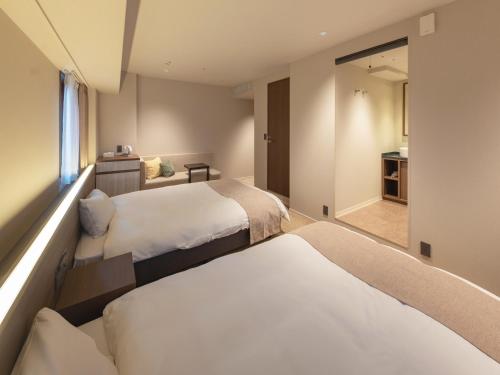 a hotel room with two beds and a window at New Osaka Hotel in Osaka