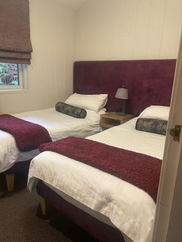 a bedroom with three beds with white and red sheets at Ardeonaig Rock in Morenish