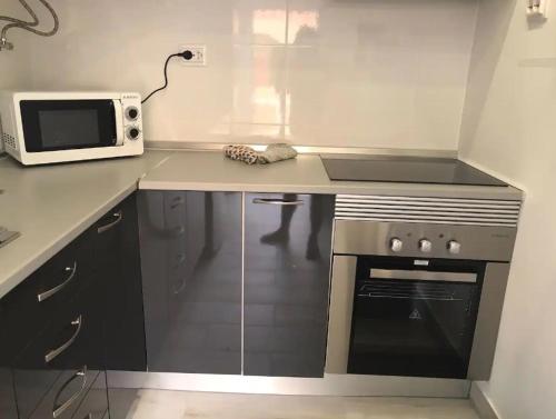 a kitchen with a stove and a microwave on a counter at Blife Delya private rooms at Faro beach in Faro