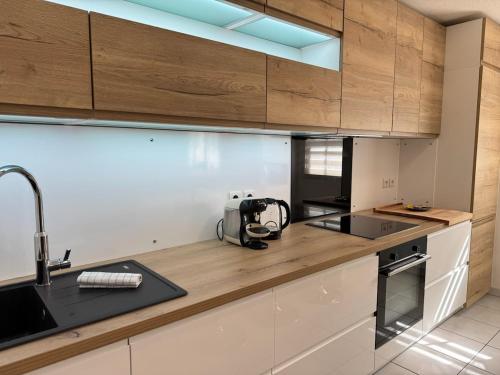 een keuken met houten kasten en een apparaat op een aanrecht bij Rives Bleues by PRIM0 C0NCIERGERIE in Pont-du-Château