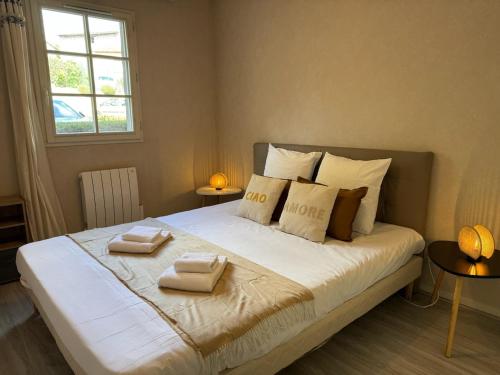 een slaapkamer met een groot bed met twee handdoeken erop bij Rives Bleues by PRIM0 C0NCIERGERIE in Pont-du-Château