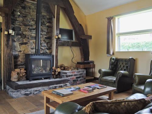 een woonkamer met een stenen open haard bij Hirros Hall Longhouse in Llanerfyl