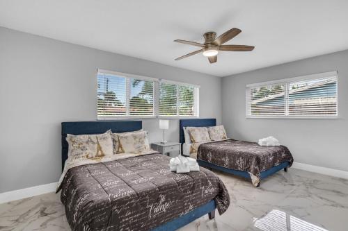 Un dormitorio con dos camas y un ventilador de techo. en Private Pool Vacation Home Near Beach Newly Renovated, en Deerfield Beach