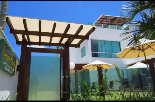 een houten pergola voor een gebouw met parasols bij Casa Oliveira in Cayru