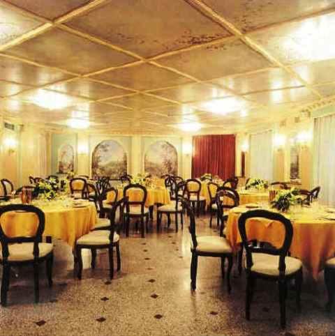 a dining room with tables and chairs with yellow table cloth at Park Hotel Villa Salzea in Trofarello