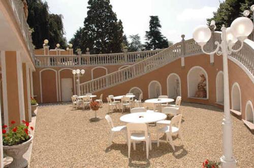a patio with tables and chairs and a building at Park Hotel Villa Salzea in Trofarello