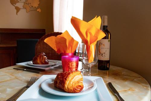 een tafel met een bord eten en een fles wijn bij Au Vent des Blés in Incourt