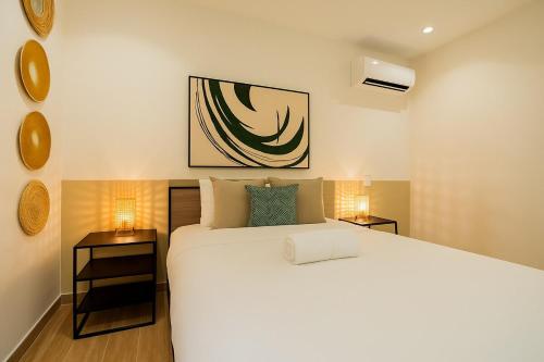 a bedroom with a large white bed and two lamps at La Cuadra - Casco Viejo in Panama City