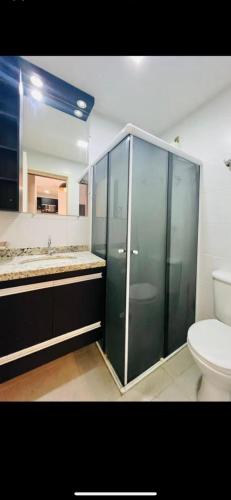 a bathroom with a glass shower and a toilet at Edifício Cristo Rei in Marília