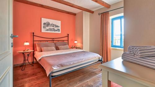 a bedroom with orange walls and a bed and a window at Rustic Villa Simone with outdoor pool in Porec in Krmenjak
