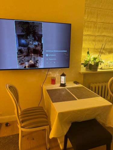 ein Tisch mit einem Stuhl und einem Fernseher an der Wand in der Unterkunft Sunny Central Apartment on Central Square in Daugavpils