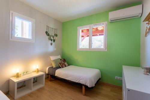 Un dormitorio pequeño con una cama y dos ventanas. en Chambre - Dorine, en Aroue