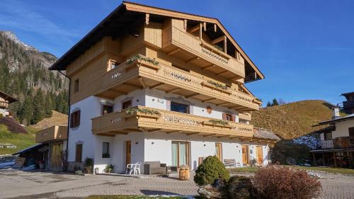 a building with wooden balconies on the side of it at Sappada Family Apartments in Sappada