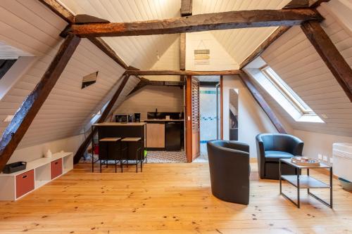 een verbouwde zolder met houten balken en stoelen en een keuken bij Les dames de Salies in Salies-de-Béarn