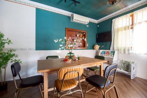 Un comedor con mesa y sillas de madera. en 嘉義行滿旅宿&包棟親子寵物烤肉平價好趣宿, en Zhuqi