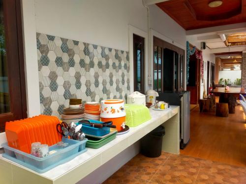 a counter with plates and bowls on it in a kitchen at เดอะเบสท์ พูลวิลล่า ขนอม in Ban Tha Chan