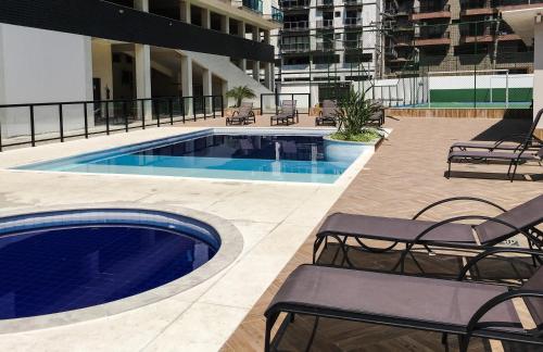 a swimming pool on the roof of a building at Apart Hotel Porto Príncipe in Cabo Frio