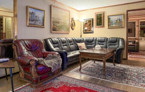 een woonkamer met een leren bank en een tafel bij 4 Bedroom Pet Friendly Home In Karlstad in Våxnäs