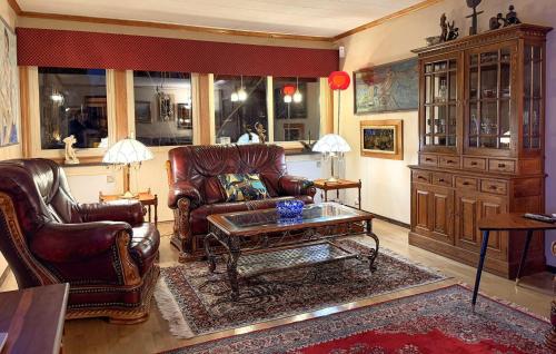 een woonkamer met lederen stoelen en een salontafel bij 4 Bedroom Pet Friendly Home In Karlstad in Våxnäs