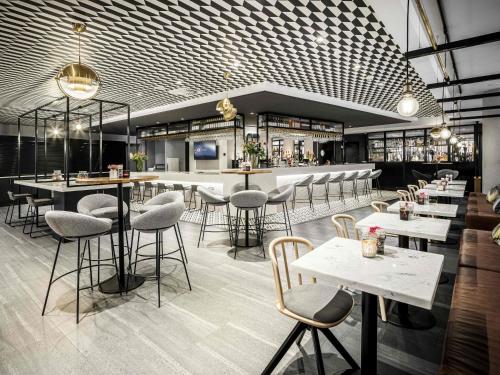 ein Restaurant mit Tischen und Stühlen und eine Bar in der Unterkunft Novotel Den Haag City Centre in Den Haag