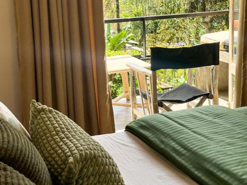 ein Schlafzimmer mit einem Bett und ein Balkon mit einem Tisch in der Unterkunft Pine Cone Cottages, Ella in Ella