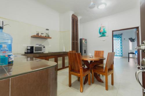 a kitchen with a table and chairs and a counter at Departamentos Blue Bacalar in Bacalar