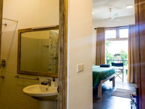 ein Badezimmer mit Waschbecken und Spiegel in der Unterkunft Pine Cone Cottages, Ella in Ella