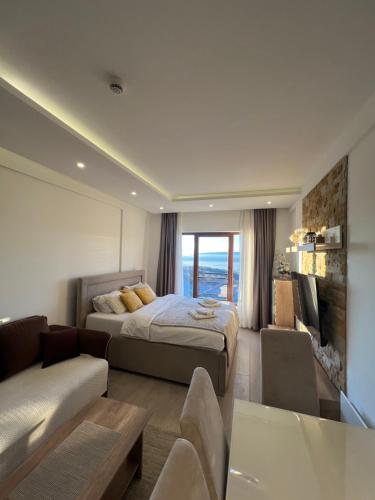a bedroom with a bed and a couch and a tv at Milmari N69 in Kopaonik