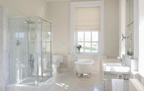a bathroom with a shower and a toilet and a sink at Buxted Park Hotel in Uckfield