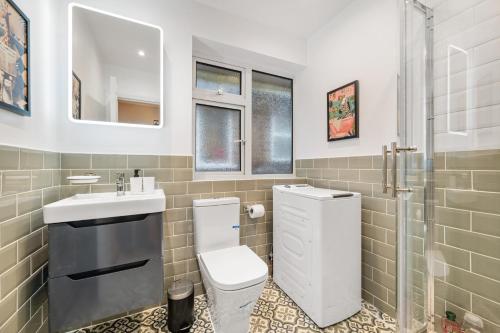 a bathroom with a toilet and a sink and a shower at Lovely Ealing 3 Bed Flat in Ealing