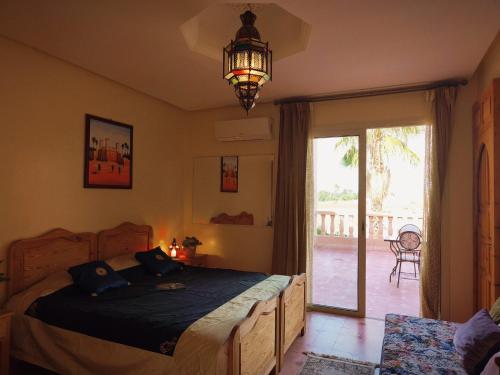 a bedroom with a bed and a sliding glass door at Villa Essalah & Spa Marrakech in Marrakech