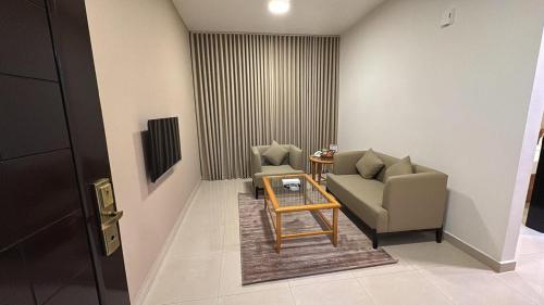 Una sala de estar con dos sillas y una mesa. en Al Khaleej Plaza Furnished Hotel Apartments, en Ajman