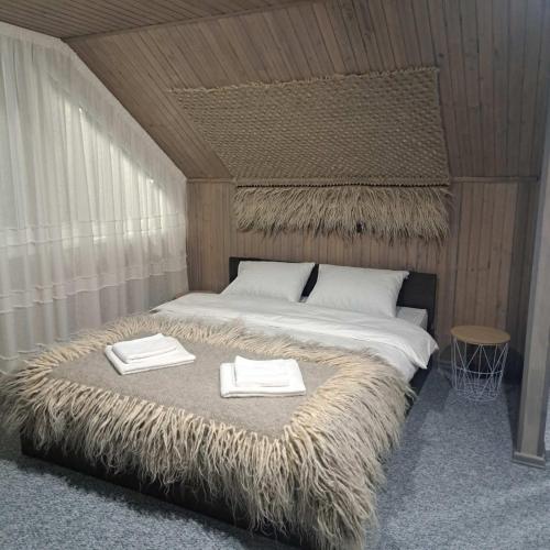 a bedroom with a large bed with two towels on it at Гори і тиша gory & tysha in Yavoriv