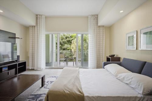 ein Schlafzimmer mit einem großen Bett und einem Fernseher in der Unterkunft Spacious 1BR Loft Villa - Pool Golf - Doral Downtown in Miami