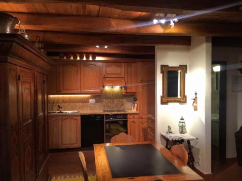 a kitchen with wooden cabinets and a table in it at Tenuta Casa Cima - tenutacasacima com - in Gudo
