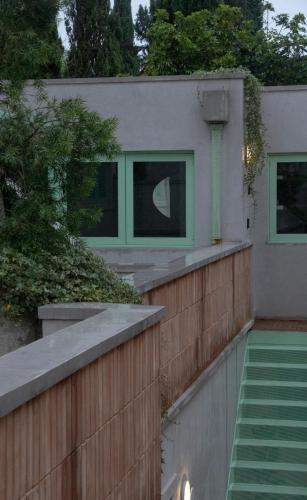 een huis met groene ramen en een houten hek. bij La Colmena in Mexico-Stad