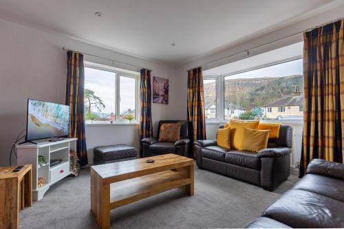 a living room with a couch and chairs and a tv at SHELTER STONE - Cottage in the heart of the Lakes in Keswick