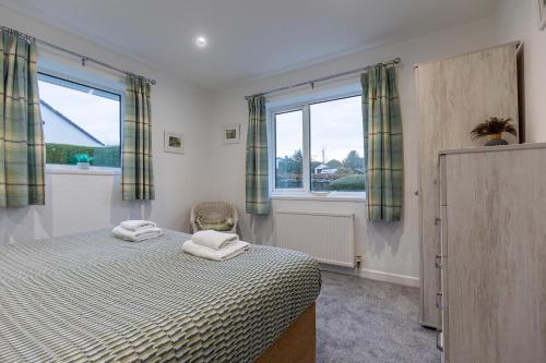 a bedroom with a bed with two towels on it at SHELTER STONE - Cottage in the heart of the Lakes in Keswick