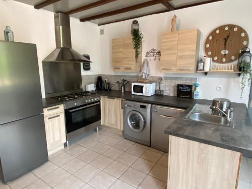 La cuisine est équipée d'un réfrigérateur, d'un évier et d'une cuisinière. dans l'établissement La maison Callinora, à La Chapelle-Saint-Étienne