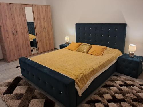 una camera da letto con un letto grande e uno specchio di Apartament NECTARIA a Băile Herculane