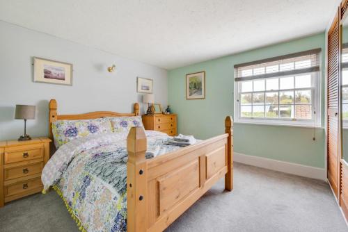 een slaapkamer met een houten bed en een raam bij 2 Bed in Beccles oc-puddin in Beccles