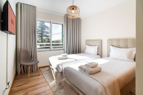 a bedroom with two beds and a window at GuestReady- Charming Condo with Pool in Caniço in Caniço