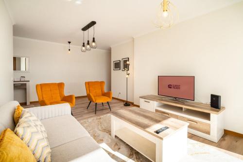 a living room with a couch and a tv at GuestReady- Charming Condo with Pool in Caniço in Caniço