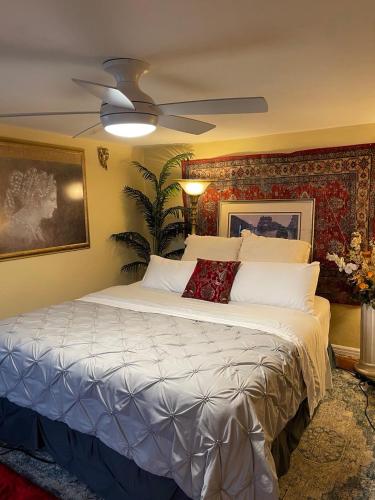 a bedroom with a large bed with a ceiling fan at Cozy room in house at Airport & Highway in Saint Louis