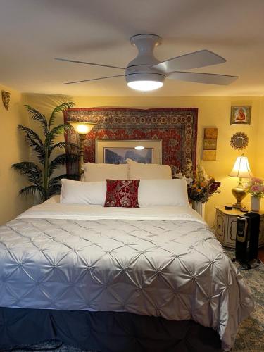 a bedroom with a large bed with a ceiling fan at Cozy room in house at Airport & Highway in Saint Louis