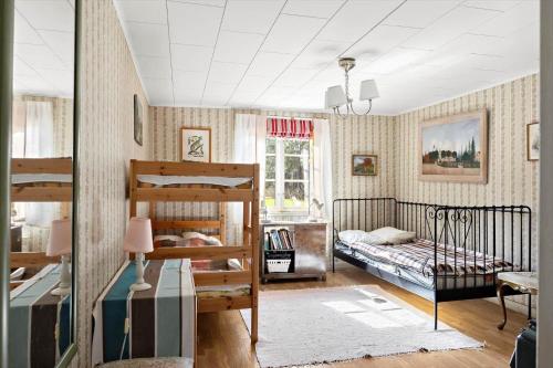 ein Schlafzimmer mit zwei Etagenbetten und einem Fenster in der Unterkunft OGO631 Boxholm - Stjärnesand Sågstugan 1 in Ormsjötorp