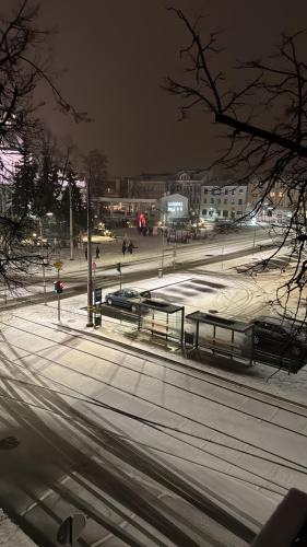 Een stadsstraat 's nachts met bankjes en auto's. bij Sunny Central Apartment on Central Square in Daugavpils