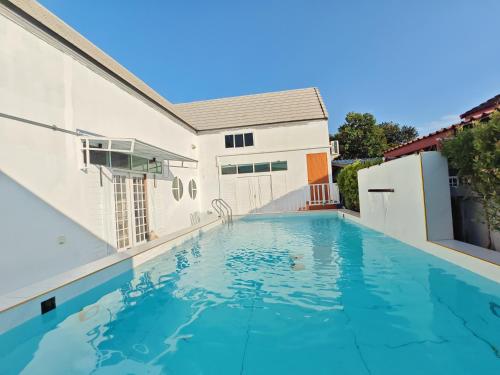 a swimming pool in front of a house at Windy Pool Villa Pattaya 3 King size bedrooms in Ban Bang Lamung